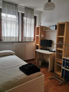 1 dormitorio con 1 cama y escritorio con ordenador en Luminoso e accogliente appartamento a San Donato, en San Donato Milanese