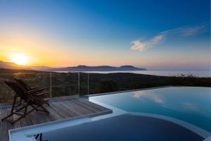 - une piscine avec une chaise et un coucher de soleil dans l'établissement Villa Sugar, à Episkopi