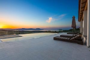 - une piscine avec un parasol et un coucher de soleil dans l'établissement Villa Sugar, à Episkopi