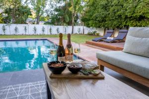 a table with bottles of wine and bowls of food at Villa Stellenbosch in Stellenbosch