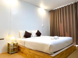 - une chambre avec un grand lit et des draps blancs dans l'établissement ฤกษ์ดี RerkDee bed and Breakfast, à Phayao