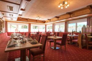 - une salle à manger avec des tables, des chaises et des fenêtres dans l'établissement Hotel Höllroah, à Kappl