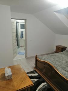 1 dormitorio con cama, mesa y espejo en Casa Balan en Câmpulung Moldovenesc