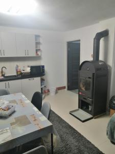 - une cuisine avec une cuisinière dans une chambre avec une table dans l'établissement Casa Balan, à Câmpulung Moldovenesc