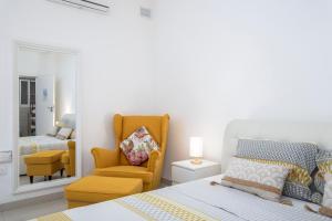 a bedroom with a bed and a chair and a mirror at Spacious, Modern & Cosy 2 Bedroom 2 Bathroom Apartment - St. Julians in St. Julianʼs
