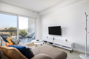 a living room with a couch and a flat screen tv at Spacious, Modern & Cosy 2 Bedroom 2 Bathroom Apartment - St. Julians in St. Julianʼs