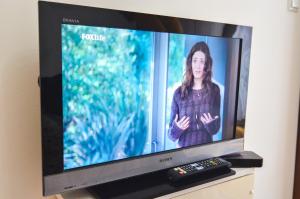 a television with a woman on the screen with a remote control at Miljacka in Sarajevo