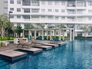 a hotel with chairs and a swimming pool in front of a building at AX Residence in Johor Bahru