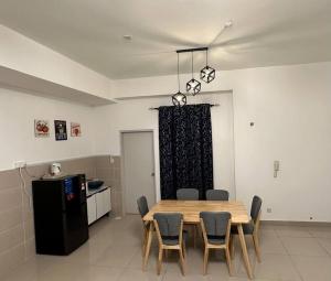 a dining room with a table and chairs and a kitchen at AX Residence in Johor Bahru