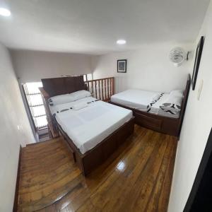 - 2 lits dans une petite chambre dotée de parquet dans l'établissement Agradable casa en Buga junto a la basílica, à Buga