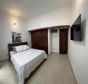una camera da letto con un letto grande e una TV a schermo piatto di Agradable casa en Buga junto a la basílica a Buga