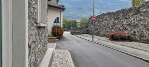 uma rua vazia ao lado de um muro de pedra com uma placa de pare em Galanthus em Aosta mais 17 fotografias