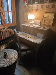 a desk with a lamp and a chair in a room at Suite Provençale in Saignon
