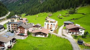 an aerial view of a village with houses on a green field at All-Suite Resort Zwieselstein - Sölden in Sölden