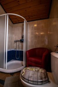 a bathroom with a tub and a red chair at Apartment Bišćan Samobor in Samobor