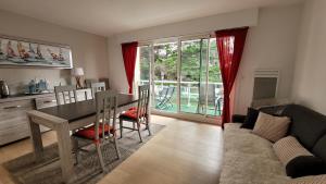 a living room with a dining room table and a couch at Résidence Port an Dro in Carnac-Plage