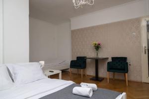 a bedroom with a bed and a table with two chairs at Apartman Panorama Glavna ulica in Užice