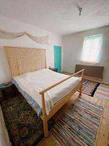ein Schlafzimmer mit einem Bett und einem Teppich in der Unterkunft Comandau 11 in Comandău
