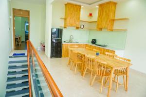 a kitchen with a wooden table and some chairs at TUY HOA CASA in Liên Trì (3)