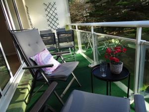 Un balcón con una silla y una mesa con flores. en Résidence Port an Dro en Carnac-Plage