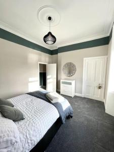 a bedroom with a white bed and a blue wall at Stevenson Apartment in Alexandria
