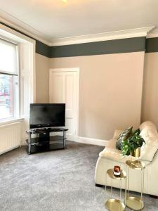 a living room with a couch and a television at Stevenson Apartment in Alexandria