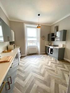 a kitchen with a wooden floor in a room at Stevenson Apartment in Alexandria