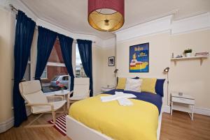 - une chambre avec un lit jaune, une table et des chaises dans l'établissement Liverpool City Stays - The Beatles Theme House - Penny Lane DD1, à Liverpool