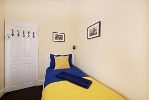 um quarto com uma cama com um cobertor amarelo e azul em Liverpool City Stays - The Beatles Theme House - Penny Lane DD1 em Liverpool