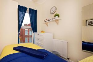 a bedroom with a bed and a clock on the wall at Liverpool City Stays - The Beatles Theme House - Penny Lane DD1 in Liverpool
