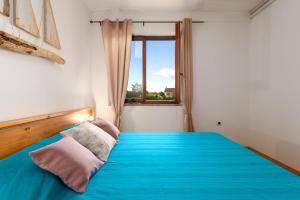 1 dormitorio con cama azul y ventana en Holiday apartment KALIĆ, en Štokovci