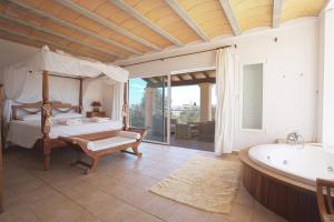 イビサ・タウンにあるVilla Tom is a lovely modern villa located near to Playa Den Bossa and Ibiza Townのベッドルーム1室(ベッド1台、バスタブ付)