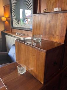 a wooden table with two glasses on top of it at Hotel du Pot d'Etain in Châlons-en-Champagne