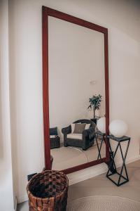 a mirror in a living room with a chair at Casa 3D'Oro Palermo in Palermo