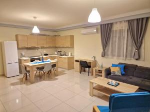 comfy center rodos - sweethome في Asgourou: غرفة معيشة ومطبخ مع أريكة وطاولة