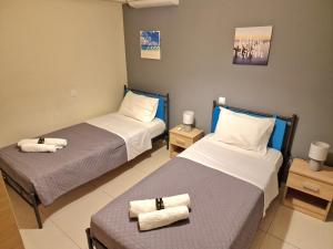comfy center rodos - sweethome في Asgourou: سريرين في غرفة عليها مناشف