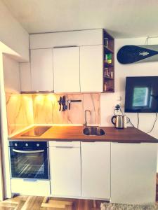 a kitchen with white cabinets and a sink at The spots - 300m from the Gondola in Brzeće +9 photos