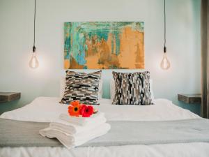 una camera da letto con un letto con asciugamani e un quadro di Giardino Boutique Hotel a Swakopmund