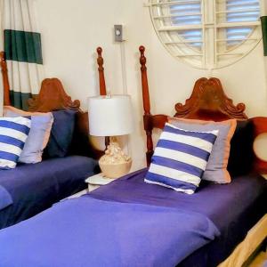 um quarto com 2 camas com almofadas azuis e brancas em Amazing Location! Walk to town, beach & dinner - PAYMENT REQUIRED TO RESERVE em Ocho Rios