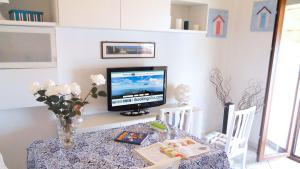 ein Esszimmer mit einem Tisch und einem TV darauf in der Unterkunft Appartamento Cosmopolis in Portoferraio