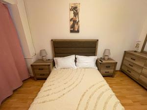 1 dormitorio con 1 cama con 2 mesitas de noche y 2 mesas en National Arena Mega Mall Elana apartment, en Bucarest