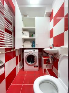 a red and white bathroom with a washing machine at National Arena Mega Mall Elana apartment in Bucharest