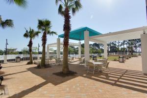 un pavillon avec des palmiers, une table et des chaises dans l'établissement Laketown Wharf Resort by Panhandle Getaways, à Panama City Beach