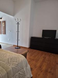 a bedroom with a bed and a dresser with a television at Alunita & Pirita, Habitación con Jardín, Terraza y WiFi en zona tranquila y céntrica in Nazaret