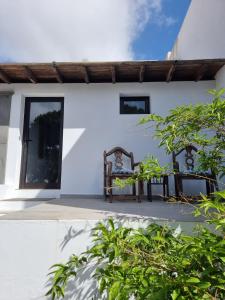 een wit huis met 2 stoelen op een patio bij Habitacion Alunita in Nazaret