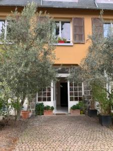 una casa naranja y blanca con árboles delante de ella en Duplex terrasse en Frehel