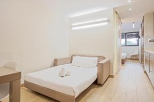 Habitación pequeña con cama y escritorio. en Aparthotel Bcn Montjuic, en Barcelona