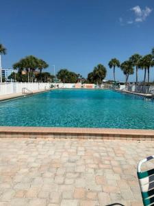 a large swimming pool with blue water and palm trees at Piece of Paradise in Clearwater Beach