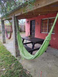 eine Hängematte vor einem Haus mit einem Picknicktisch in der Unterkunft Nalu in La Paloma