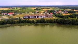 an aerial view of a large building next to a lake at Willa Raj - Apartamenty nad jeziorem KA-BOATS in Rajgród